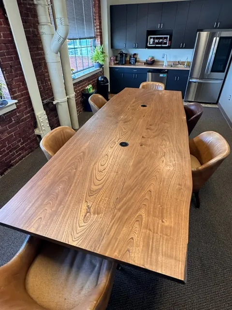 Live edge wood conference table with a black base, built by Baltimore furniture maker Tyler Jones